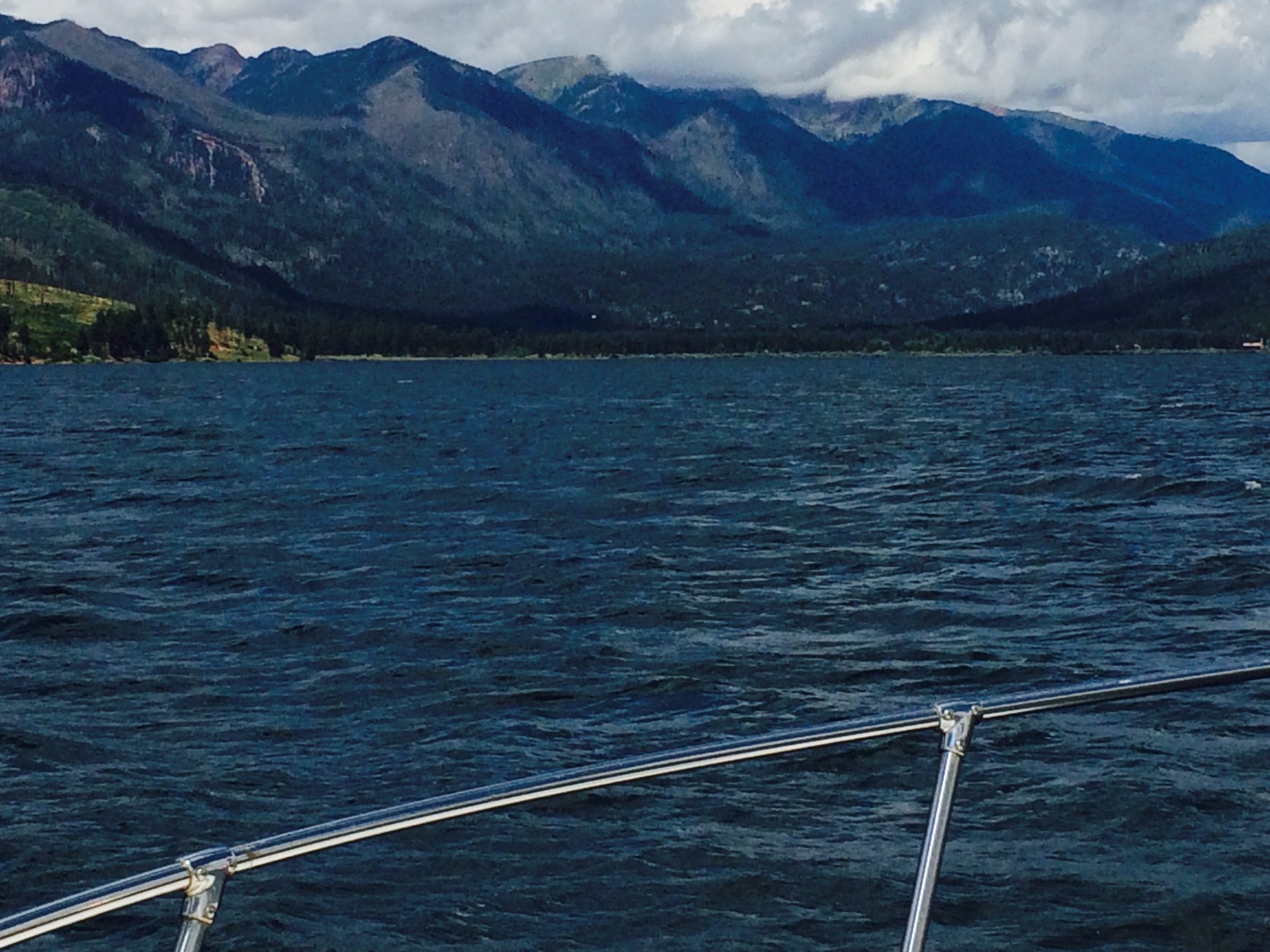 a small boat in a body of water with a mountain in the background