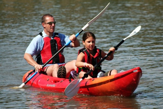 a group of people rowing a boat in the water